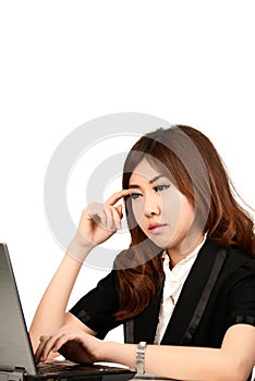 Busy young business woman working at desk typing on a laptop