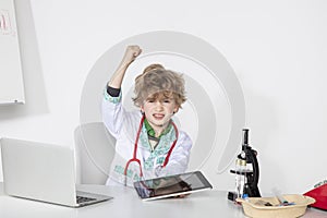 Busy young doctor threatens with his fist, sitting in his office