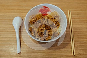 Buta donburi rice with pork with spoon and chop stick