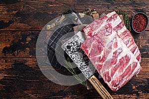 Butcher board with rack of raw pork spare ribs. Wooden background. Top view. Copy space