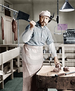 Butcher chopping meat with cleaver photo