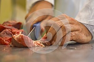 Butcher cleaning the meat from impurities