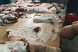 a butcher cutting slices of pork at the slaughterhouse, food industry