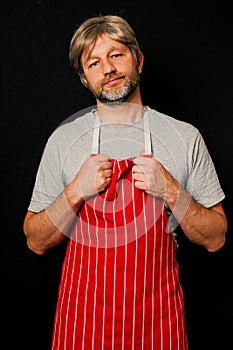Butcher or fishmonger in grey shirt and red and white stripe apron