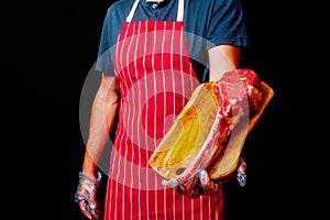 Butcher holding wooden board with raw tomahawk steak on the bone and black background. Prime cut of beef. High quality product