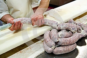 Butcher making links of salami
