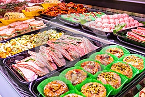 Butcher, meat department. Several products displayed in a showcase.
