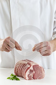 Butcher prparingng raw rolled meat enclosed