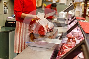 Butcher sells chopped beef meat at a market