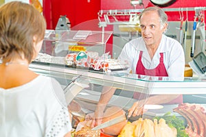 Butcher serving customer at deli counter