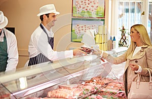 Butcher Serving Customer In Shop