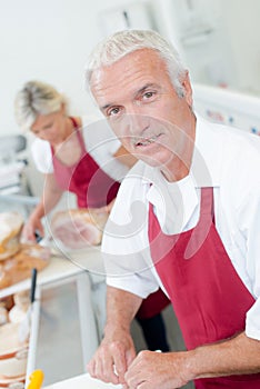 Butcher serving female customer