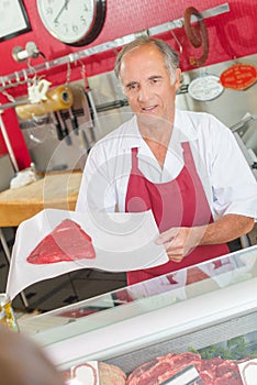 Butcher showing steak to customer photo