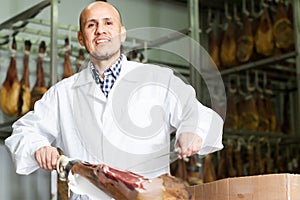 Butcher slicing jamon in delicatessen store