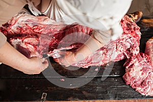 Butcher slicing piece pork carcass. Top view