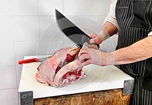 Butcher using a cleaver to cut rib eye steaks