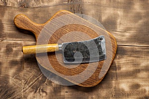 Butcher. Vintage butcher meat cleavers with chopping board on dark wooden background.