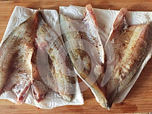 butchered, prepared for cooking fish on the table.