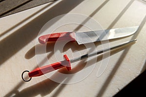 Butchers knife and linchpin on a cutting board