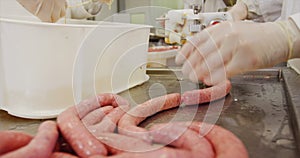 Butchers making sausage from mincer