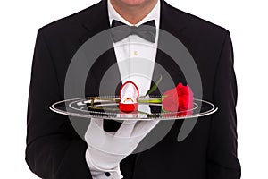 Butler with engagement ring and red rose