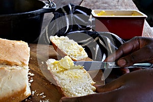 Butter being spread on white bread