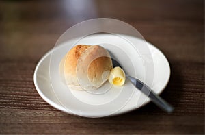 Butter with bread on white plate : closeup