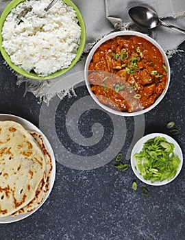Butter chicken served with rice and flatbread