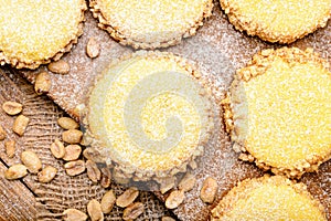 Butter cookies (alfajores) with caramel and peanut on wooden background.