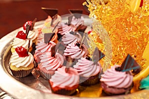 Butter Cream Cupcakes Assortment on silver tray with candy art decor. Hotel restaurant food catering service buffet cocktail banqu