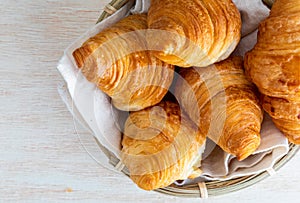 Butter croissants in small wicker basket. Aerial top view on c