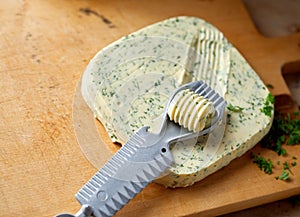 Butter curler cutting a pat of herb butter