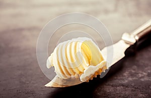 Butter on a Knife on Top of a Wooden Table photo
