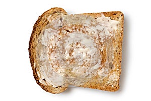 Butter spread on a single slice of whole wheat toast isolated on