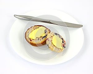 Buttered berry muffin on plate with knife