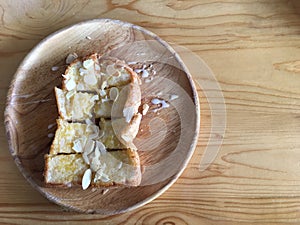 Buttered bread on a wooden plate