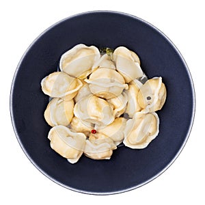 Buttered Pelmeni in black bowl isolated on white