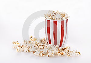 Buttered popcorn in a striped bowl over white background