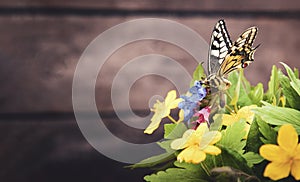 Butterfly and bouquet of field wild flowers in a vase on old boards