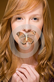 Butterfly covering woman's mouth