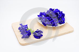 Butterfly pea flower in a cup on wooden plate on white backgroun