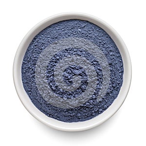 Butterfly pea flower powder or blue matcha in round bowl isolated on white. Top view