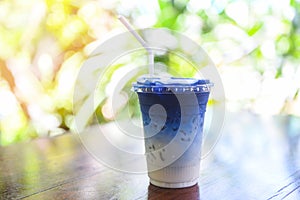 Butterfly pea juice or blue pea flower herbal tea with milk for drink on wooden background