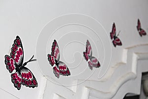 butterfly stickers on the wall of a house. Size of the art is made gradualy decreased as it moves away photo