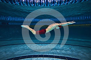 Butterfly swim style. Athletic young man, swimmer in motion training, preparing for competition, swimming in pool