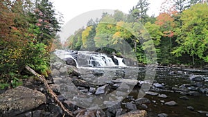 Buttermilk Falls in Long Lake, NY, Adirondacks, surrounded by vivid fall foliage on an overcast afternoon