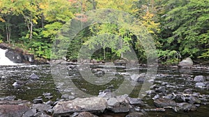 Buttermilk Falls in Long Lake, NY, Adirondacks, surrounded by vivid fall foliage on an overcast afternoon