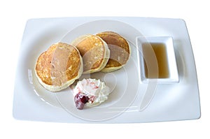 Buttermilk pancakes with maple syrup and weep cream in plate on