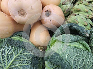 Butternut sqash, green cabbage and artichokes in front of the grocery store