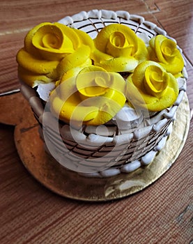 A butterscotch cake with yellow flowers on top.